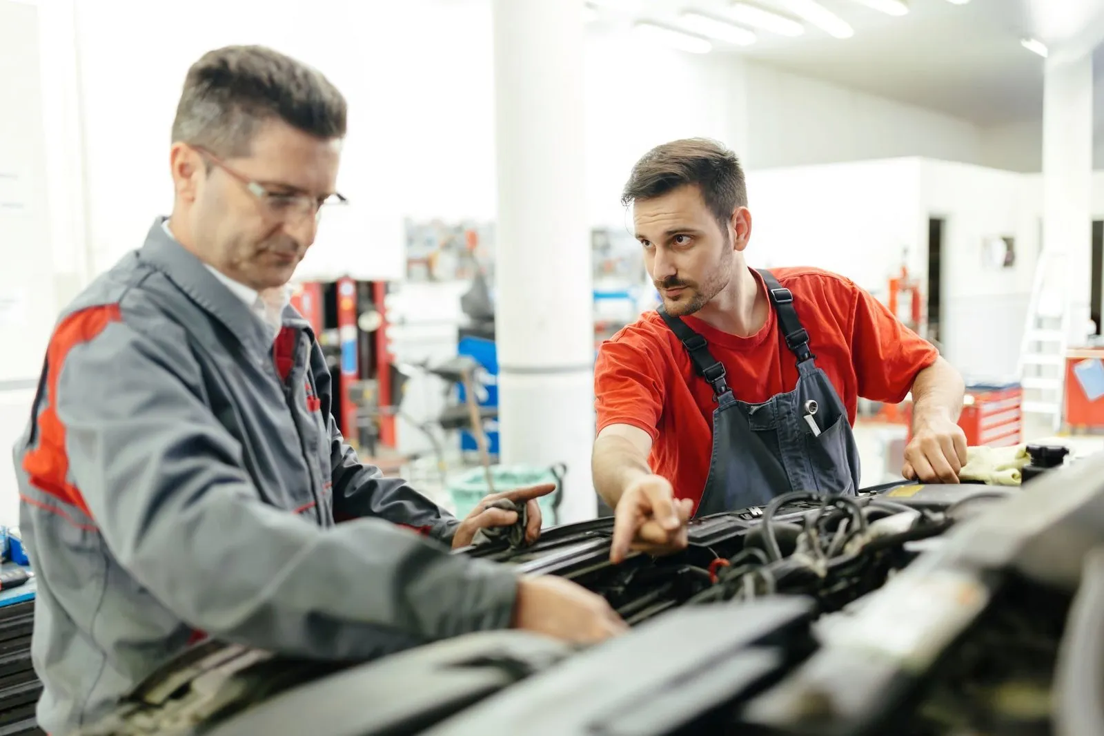 Two mechanics repairing a car